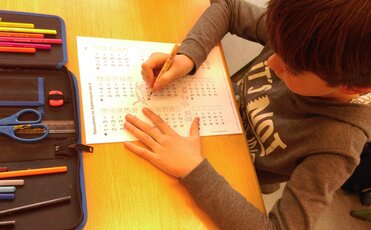 Ein Junge rechnet mit einem Zahlenbogen